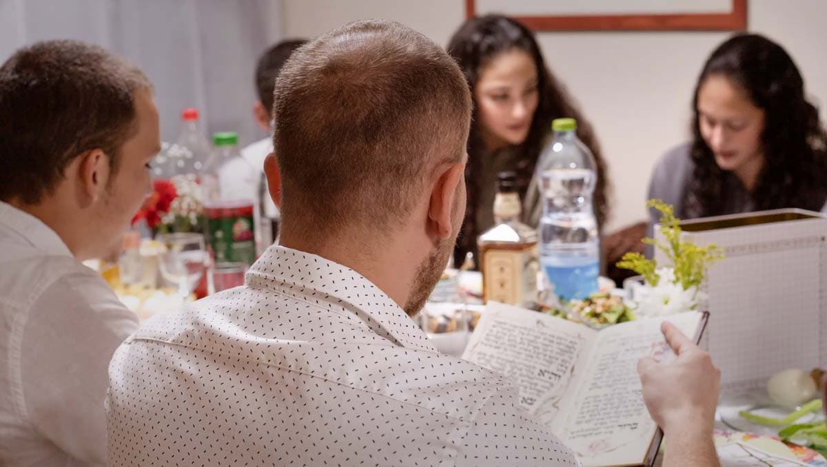 Family celebrating Passover with Haggadah