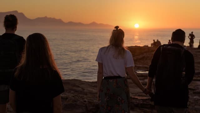 People walking toward beach sunset