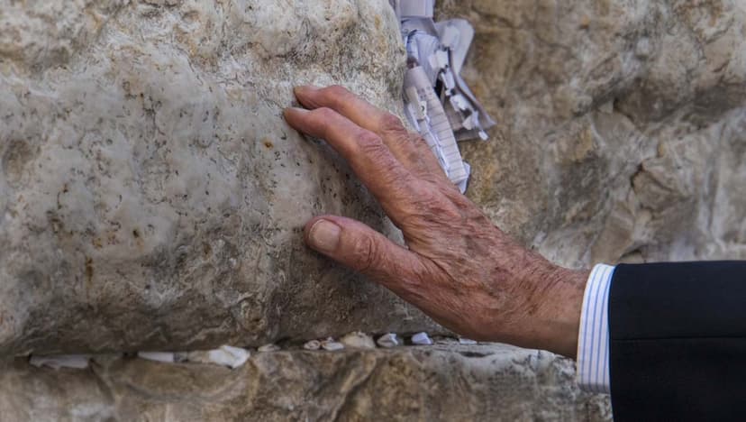 Hand touches a stone of the Western Wall