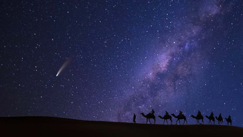 Camel procession at night with comet