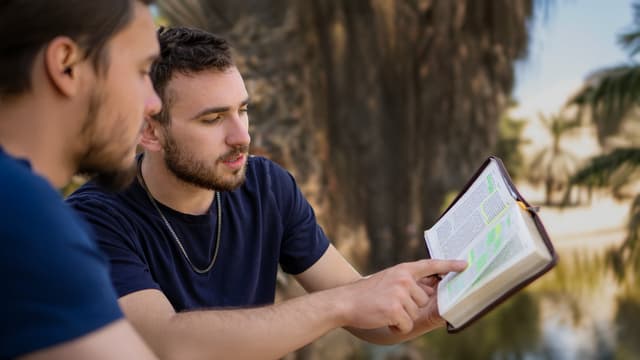Young man sharing Scripture with his friend
