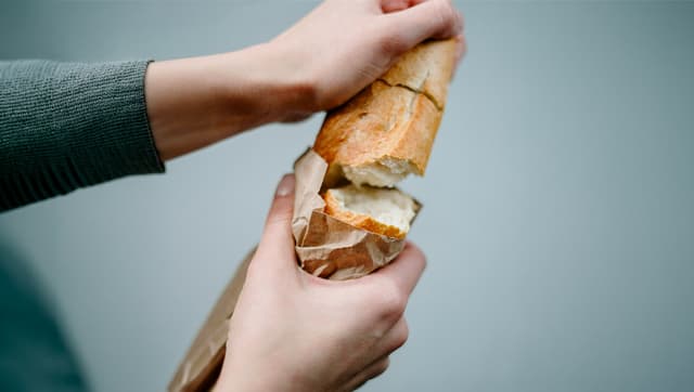 Close up to hands breaking bread