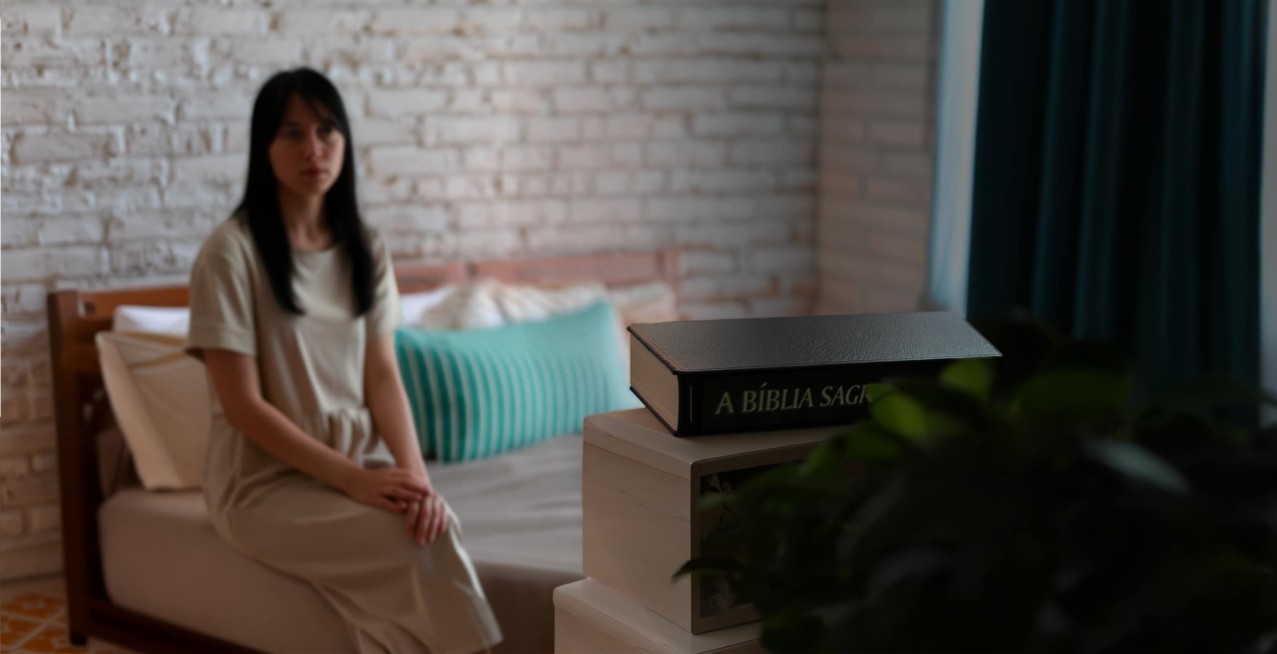 Young woman sitting thoughtfully beside a Bible in a quiet room, reflecting on faith and Scripture.