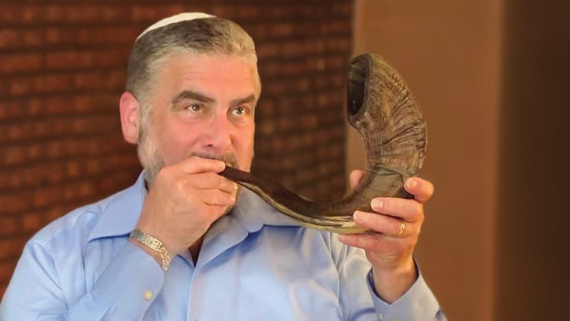 Close-up of a man blowing a shofar for the Jewish High Holidays