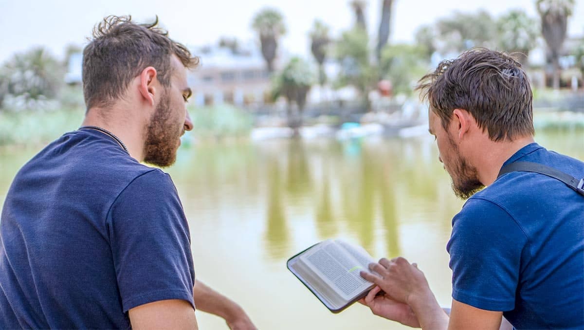 Two young men reading the Bible, outdoors, Tel Aviv