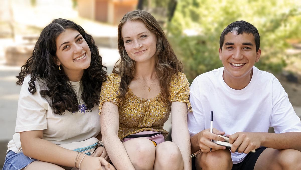 Featured-Raising-Kids-Who-Are-Both-The-Teen-Years Teenagers sitting together while attending a Camp Gilgal event.
