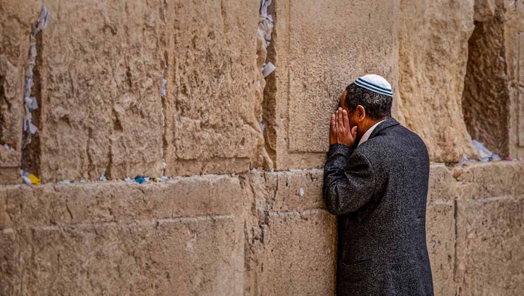 Man praying at wall
