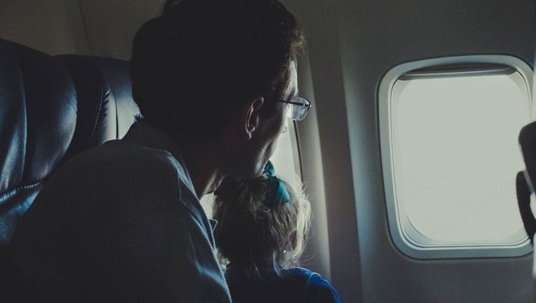 Jewish father and son looking out the window of an airplane.