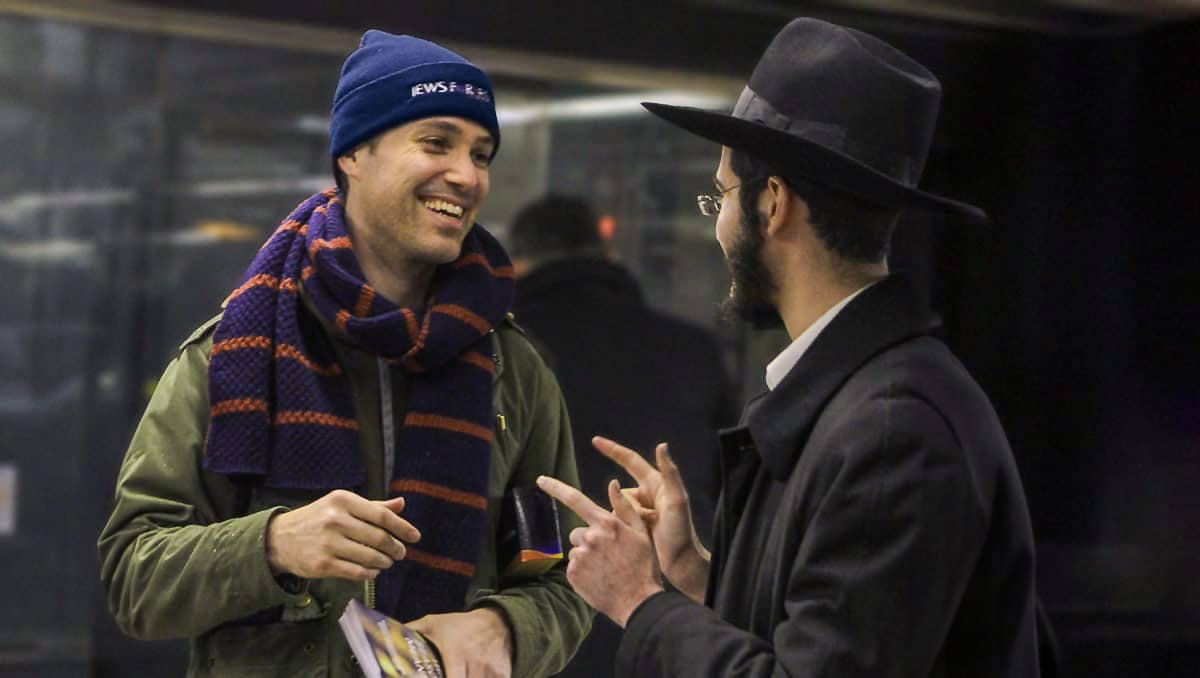 Jewish man talking and smiling to young orthodox jewish man